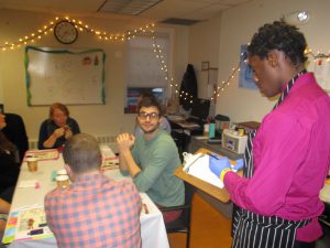 A student acting as the waiter taking an order from a teacher at the House of Burgers