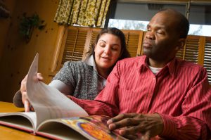 a volunteer reads for a visually impaired man