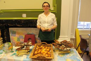 A student serving delicious treats she and other students made for the guests