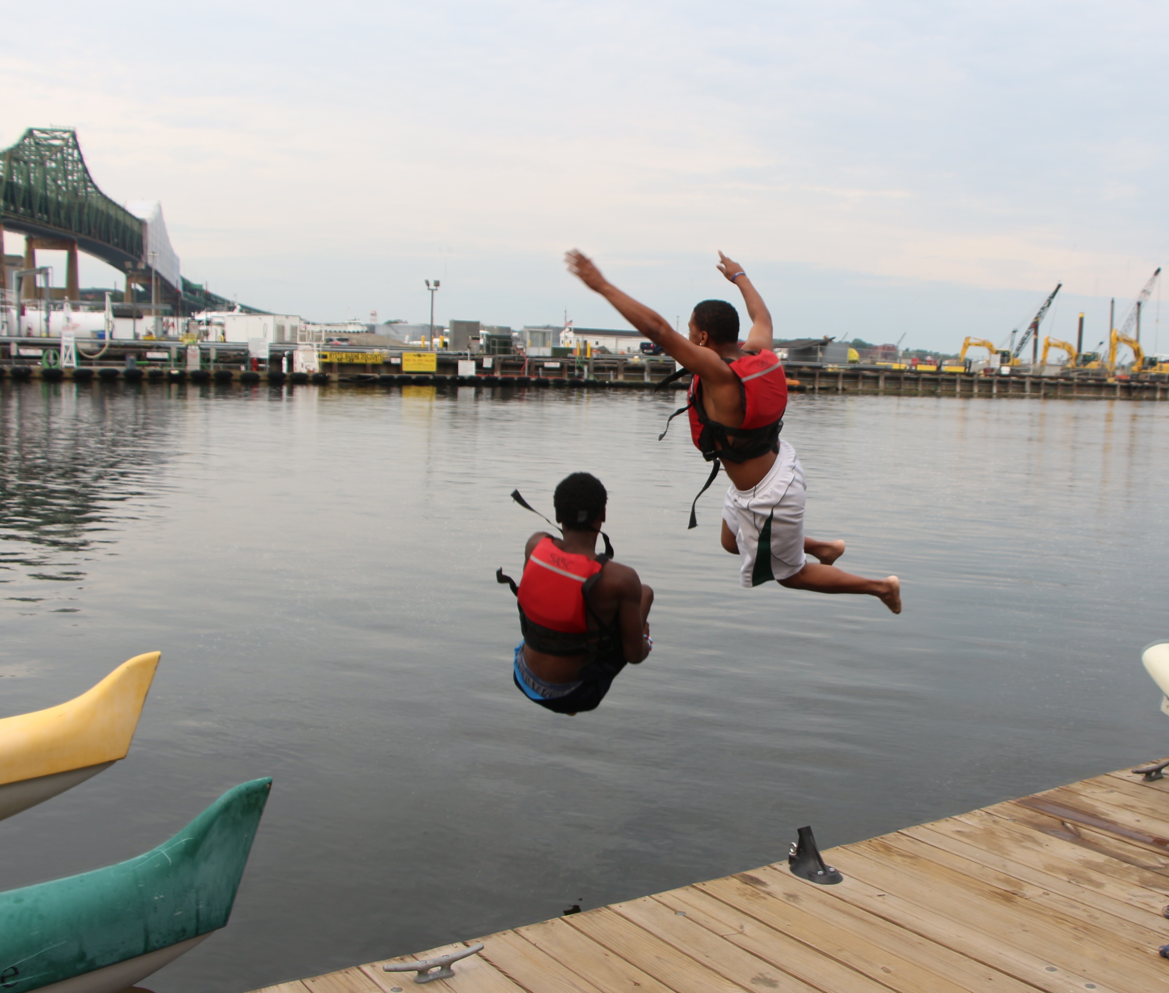 Two special needs students from Ivy Street School jump off a dock into the water