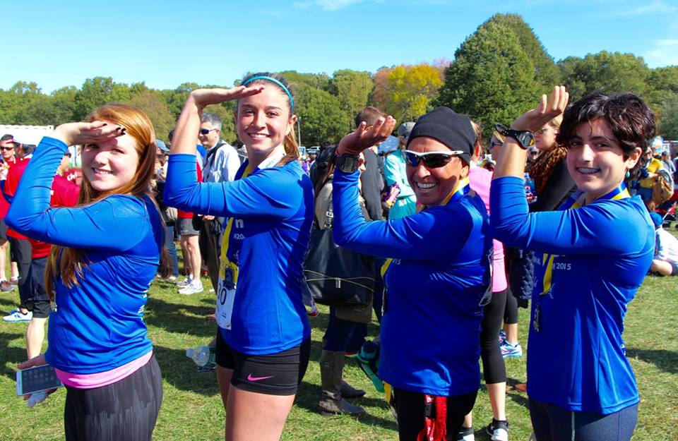 Team With A Vision runners and Delta Gamma guides give the DG salute after a race
