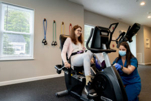 A MAB occupational therapist assisting a participant with a stationary bike