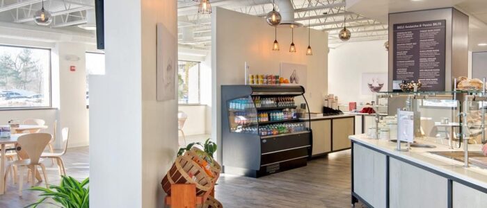 a brightly lit cafe ordering area with a case of food offering.