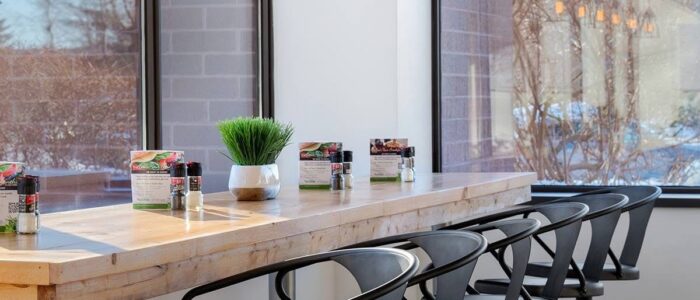 A chic cafe bar with metal stools and overhead lighting.